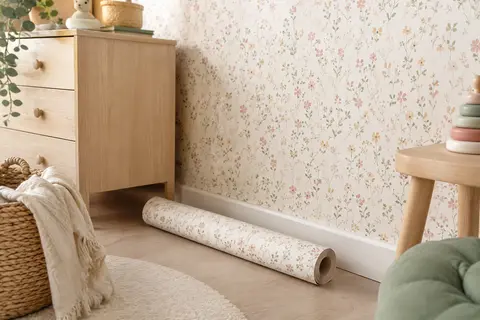 Papier peint intissé à petites fleurs vertes et rosées sur le mur d’une chambre d’enfant