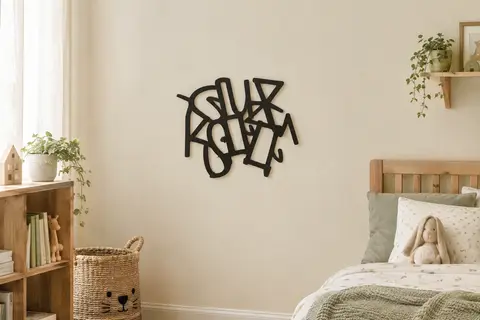 Plaque murale personnalisée en métal noir installée sur un mur crème dans une chambre d’enfant