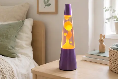 Lampe à mouvements liquides violette, avec cire jaune et orange, posée sur une table en bois clair.