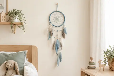 Attrape-rêves mural bleu en toile tissée, perles et plumes suspendu dans une chambre d’enfant lumineuse.