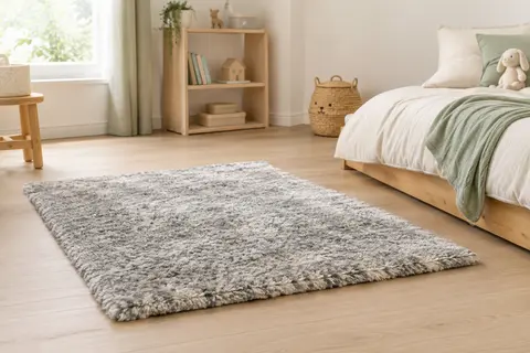 Tapis shaggy rectangulaire gris et blanc posé près d’un lit dans une chambre d’enfant lumineuse.